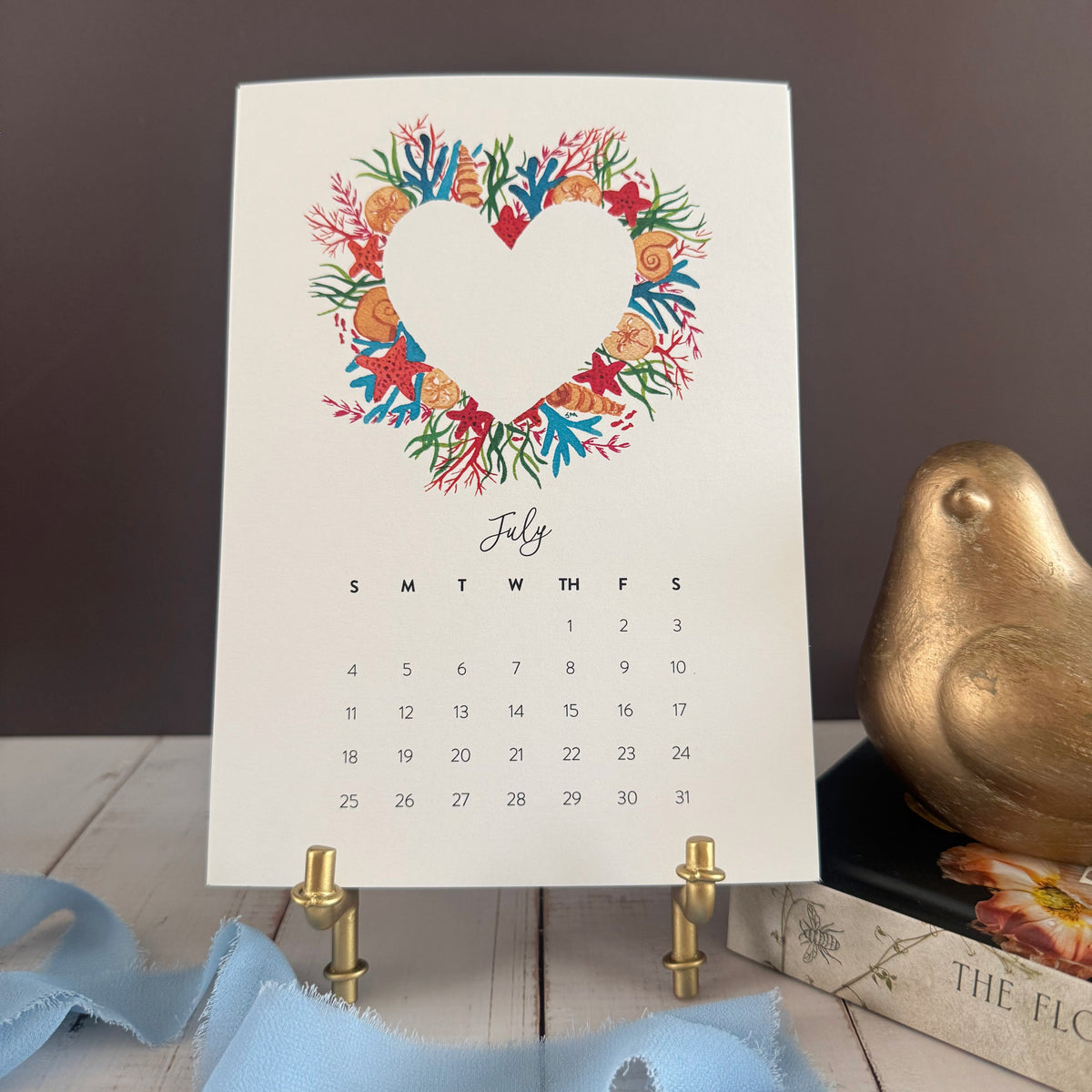 July page with a bright heart wreath of coral, seashells, and fish